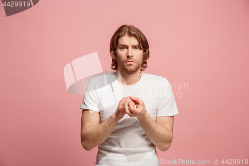 Image of Let me think. Doubtful pensive man with thoughtful expression making choice against pink background
