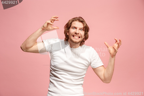 Image of Portrait of an angry man looking at camera isolated on a pink background