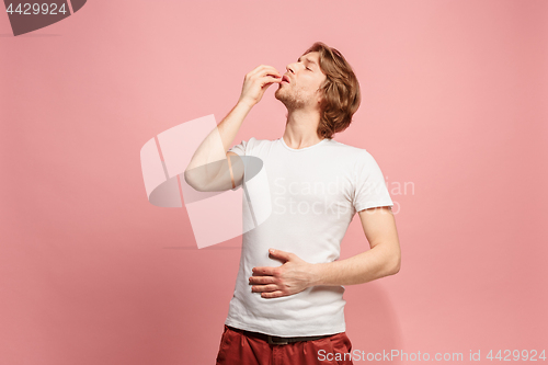 Image of The happy business man standing and smiling against pink background.