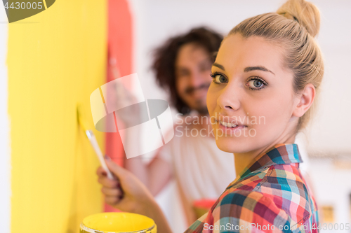 Image of couple painting interior wall