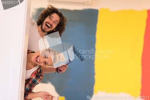 Image of portrait of a couple painting interior wall