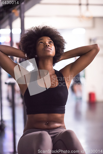 Image of black woman doing sit ups at the gym