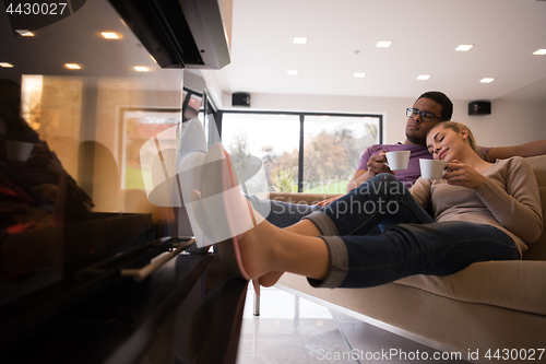 Image of Young multiethnic couple  in front of fireplace