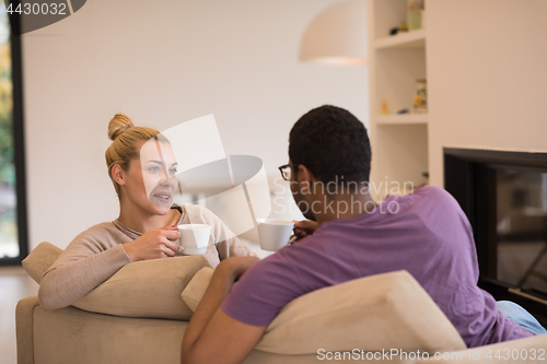 Image of Young multiethnic couple  in front of fireplace