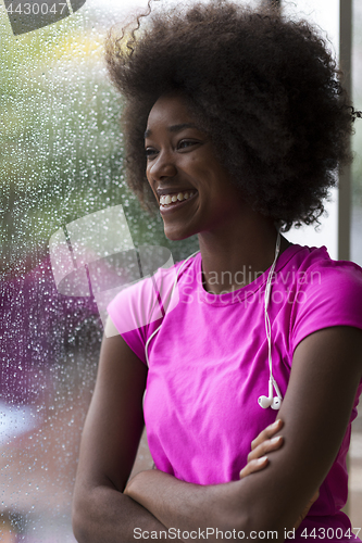 Image of portrait of young afro american woman in gym while listening mus