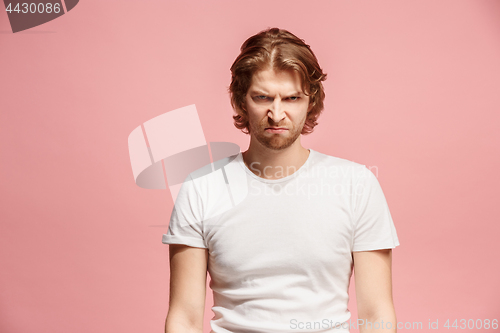 Image of Portrait of an angry man looking at camera isolated on a pink background