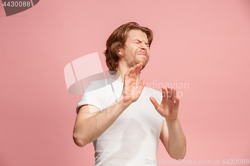 Image of Let me think. Doubtful pensive man with thoughtful expression making choice against pink background