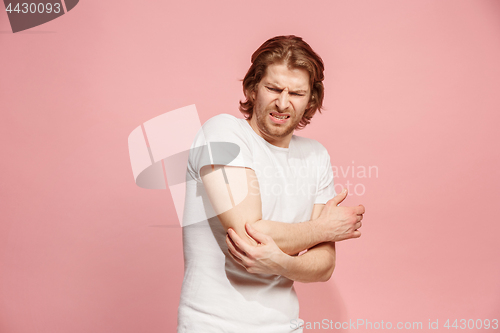 Image of Young man with disgusted expression repulsing something, isolated on the pink