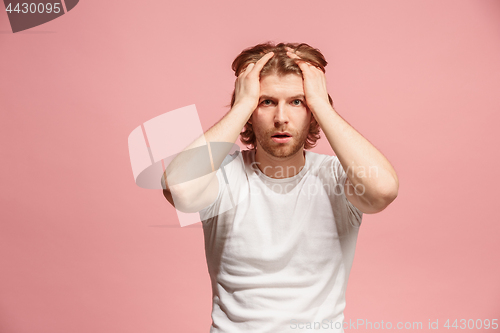 Image of man having headache. Isolated over pink background.