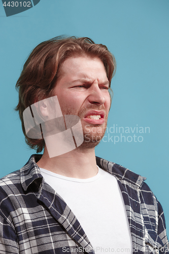 Image of Let me think. Doubtful pensive man with thoughtful expression making choice against blue background