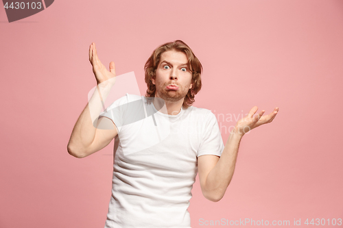 Image of Beautiful man looking suprised and bewildered isolated on pink