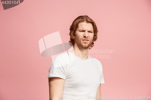 Image of Let me think. Doubtful pensive man with thoughtful expression making choice against pink background