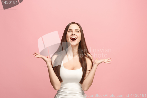 Image of The happy business woman standing and smiling against pink background.