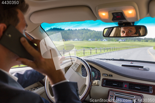 Image of Man using cell phone while driving