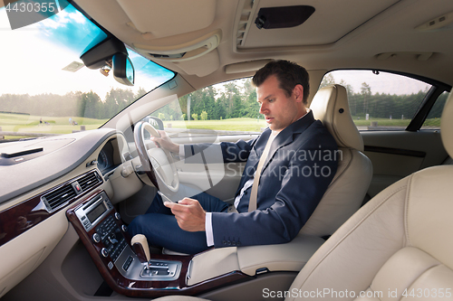 Image of Man using cell phone while driving