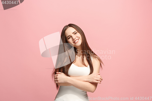 Image of The happy business woman standing and smiling against pink background.