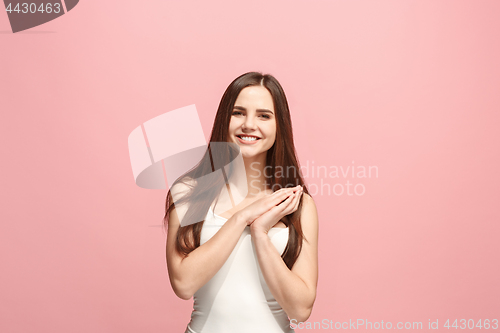 Image of The happy business woman standing and smiling against pink background.