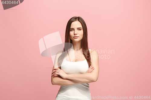 Image of The happy business woman standing and smiling against pink background.