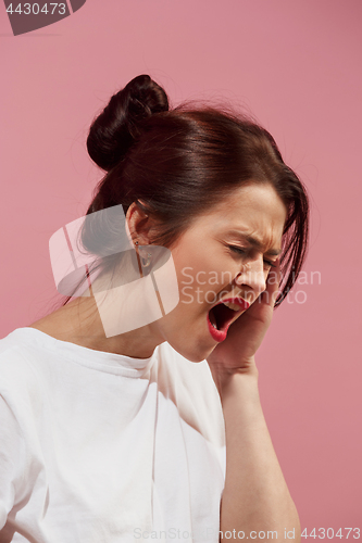 Image of Woman having headache. Isolated over pink background.