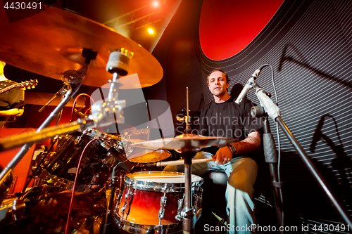 Image of Drummer playing on drum set on stage.