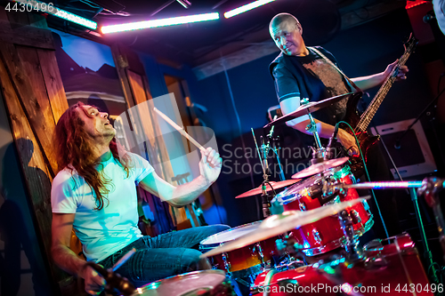 Image of Drummer playing on drum set on stage.