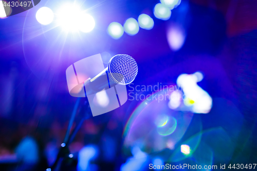 Image of Microphone on stage against a background of auditorium.