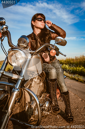 Image of Biker girl sitting on motorcycle