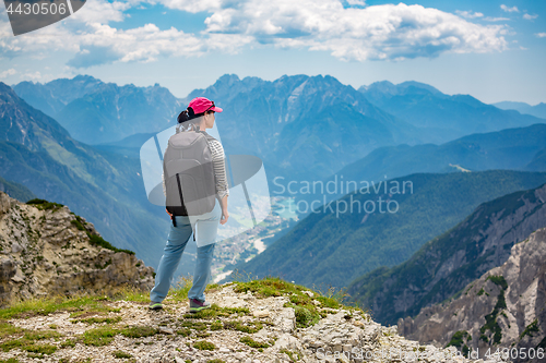 Image of Hiker woman standing up achieving the top Dolomites Alps.