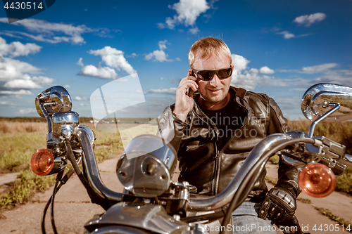 Image of Biker talking on a smartphone.