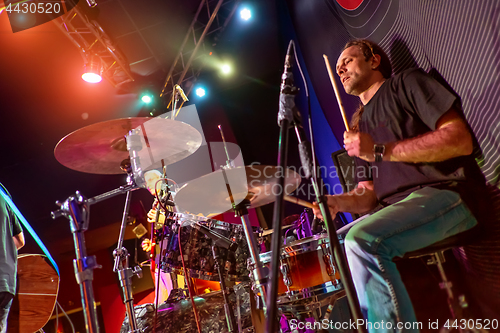 Image of Drummer playing on drum set on stage.