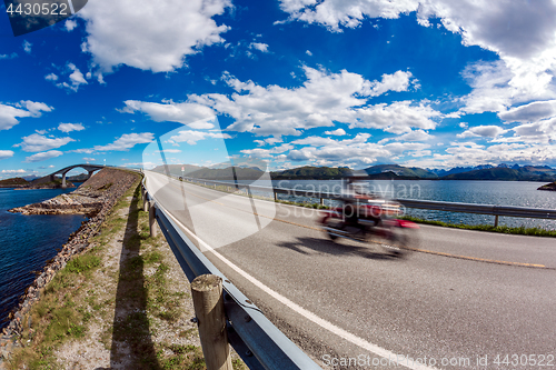 Image of Biker rides a road with Atlantic Ocean Road in Norway.