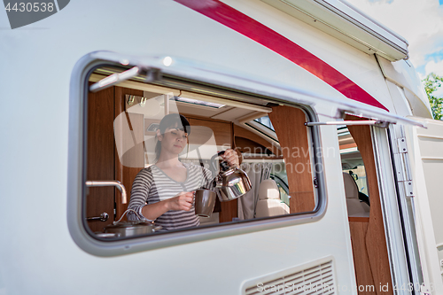 Image of Woman cooking in camper, motorhome interior