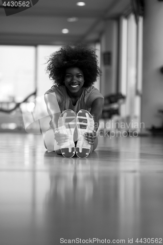 Image of woman in a gym stretching and warming up before workout