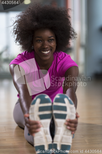 Image of woman in a gym stretching and warming up before workout
