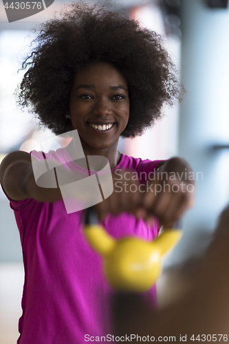 Image of woman working out in a crossfit gym with dumbbells