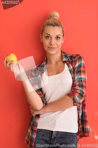 Image of woman over color background plays with apple