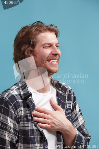 Image of The happy businessman standing and smiling against blue background.