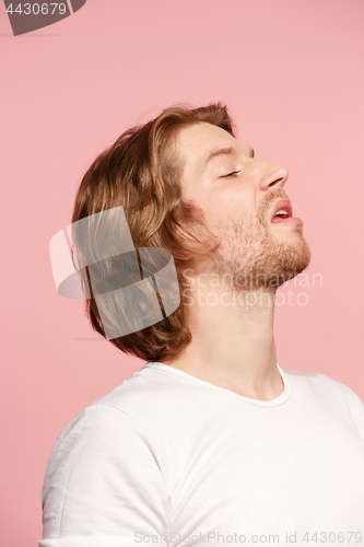 Image of Suspiciont. Doubtful pensive man with thoughtful expression making choice against pink background