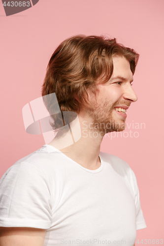 Image of The happy businessman standing and smiling against pink background.