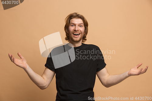 Image of The young attractive man looking suprised isolated on pastel