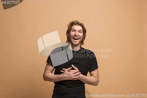 Image of The happy business man standing and smiling against pastel background.