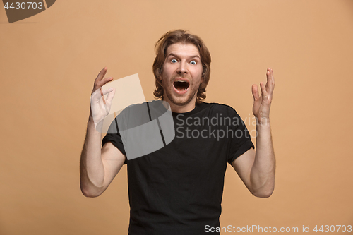 Image of The young attractive man looking suprised isolated on pastel