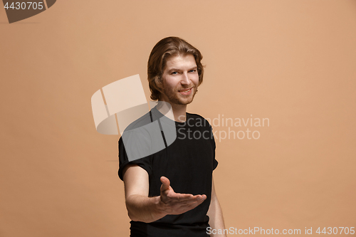 Image of The happy businessman standing and smiling against pastel background.