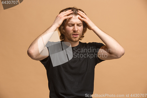 Image of Man having headache. Isolated over pastel background.