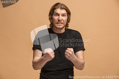 Image of The young emotional angry man screaming on pastel studio background