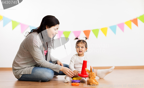 Image of mother and baby daughter playing with pyramid toy