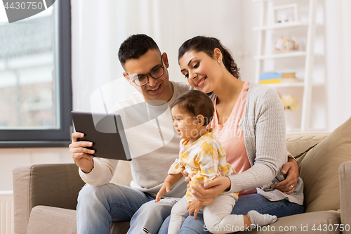 Image of mother, father and baby with tablet pc at home