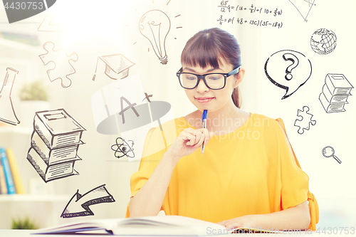 Image of smiling young asian woman reading book at home