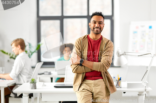 Image of smiling indian man with smart watch at office