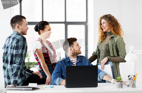 Image of creative team with laptop working at office